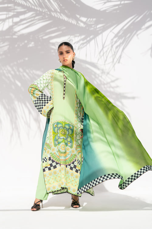 Woman wearing a green and patterned outfit with a matching scarf against a white background